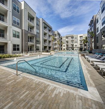 A large swimming pool in the middle of a courtyard surrounded by apartment buildings.